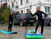 فتيات يلفتن الأنظار لمشكلة تجمع المياه فى شارع مدينة روسية بطريقة مميزة.. صور