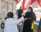 قياس حرارة الناخبين المتواجدين أمام لجان انتخابات مجلس النواب بالفيوم.. صور