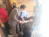 رئيس لجنة يخرج لمساعدة عجوز فى الإدلاء بصوتها فى الإسكندرية.. صور