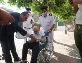 رئيس لجنة فرعية بالعمرانية يساعد "قعيد" للإدلاء بصوته بانتخابات النواب.. صور