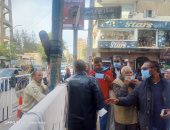 الشرطة توزع الكمامات على الناخبين فى لجان بنى سويف.. صور