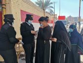 الشرطة توزع الكمامات على الناخبين فى لجان أسوان.. صور 