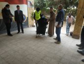 قوات التأمين تساعد مسنة على الإدلاء بصوتها بجولة الإعادة فى القليوبية