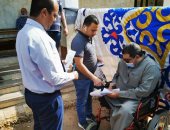 قاض بالشرقية يخرج من مكتبه لمساعدة ناخب من ذوي الاحتياجات الخاصة فى التصويت.. صور