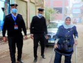 رجال الشرطة يساعدون سيدة من ذوى الاحتياجات للإدلاء بصوتها فى المنوفية