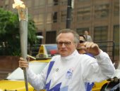 شاهد المذيع الراحل لارى كينج يرفع الشعلة الأولمبية فى لوس أنجلوس 