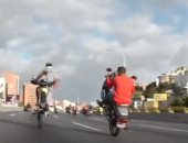 سائق دراجات يقدم حركات بهلوانية بدراجة نارية فى شوارع فنزويلا.. فيديو