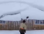 شاب يتعرض لموقف طريف خلال إزالة الثلوج من سطح منزله.. فيديو وصور
