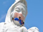 تمثال بوذى ضخم يرتدى كمامة فى مدينة يابانية للتوعية بمخاطر كورونا.. صور