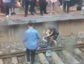 شهامة شاب تنقذ سيدة تعرضت للإغماء بعد سقوطها على قضبان قطار .. فيديو وصور
