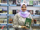 زينب عبد اللاه مع كتابها "فى بيوت الحبايب.. الأبناء يفتحون خزائن الأسرار" بمعرض الكتاب