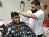 "حلاق" يرسم البهجة على وجه مرضى مستشفى جامعة طنطا بتصفيف شعرهم مجانا