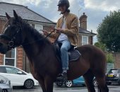 شاب بريطانى يسخر من أزمة الوقود بجولة على ظهر حصانه بين السيارات المعطلة.. فيديو