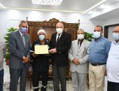 محافظ قنا يكرم عامل نظافة لتفانيه وإخلاصه فى العمل.. صور