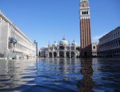 غرق مدينة البندقية وسياح يتحدون الفيضانات بارتداء أحذية مقاومة للمياه.. صور