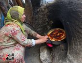 صورة اليوم.. محلاها عيشة الفلاحة.. سيدة ريفية تطهو الرز المعمر فى فرن فلاحى