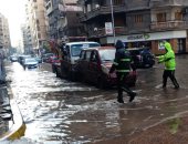 الإسكندرية قبل وبعد النوة.. رجال المرور يساعدون قائدى السيارات خلال الأمطار