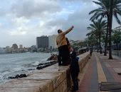 فوتوسيشن تحت المطر.. أهل الإسكندرية يستمتعون بالشتاء ويلتقطون السيلفى فى النوة