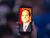 شاب يرفع صورة الرئيس السيسي خلال افتتاح منتدى شباب العالم بشرم الشيخ