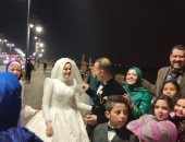 عريس وعروس يتحديان الأمطار على كورنيش بنى سويف.. فيديو وصور