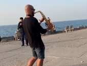 "محمد" ينشر البهجة فى شوارع الإسكندرية بالعزف على الساكسفون