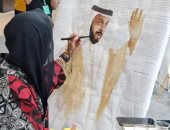 فنانة ترسم الشيخ خليفة بن زايد بالقهوة فى معرض أبوظبى للكتاب 2022 .. صور