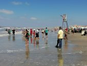 فرحة إجازة العيد مستمرة على شاطئ بورسعيد رغم رفع الرايات السوداء.. صور