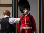 صورة اليوم.. شرطى يسقى جنديا من حرس قصر باكنجهام فى أحر يوم ببريطانيا