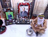 الحسين شيخو سفير الثقافة بالعالم يفترش الجناح المصرى بجوار صورة الرئيس السيسى