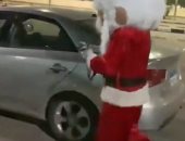 احتفالات رأس السنة.. شاب يرتدى ملابس "بابا نويل" لمسح السيارات ببورسعيد.. صور