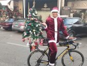 شاب يستقل دراجة ويجوب شوارع بورسعيد بملابس بابا نويل وشجرة الكريسماس.. صور