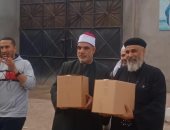 كاهن كنيسة بالإسكندرية يشارك فى توزيع صكوك إطعام مع الأوقاف 