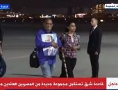 مواطن عائد من السودان يحمل صورة الرئيس السيسي لدى وصوله مطار قاعدة شرق
