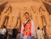 سائح آسيوى يرتدى "زى بكار" خلال جولته السياحية بمعبد أبو سمبل