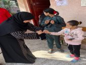 ناخبة تصطحب أطفالها بالانتخابات فى منشأة القناطر وتغمس أصابعهم فى الحبر..صور