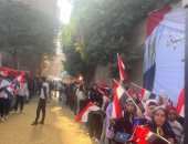 شباب أرض اللواء يرفعون علم مصر خلال مشاركتهم بانتخابات الرئاسة 2024