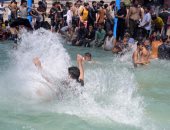 الباكستانيون يهربون من ارتفاع درجات الحرارة إلى السباحة والقفز فى الماء