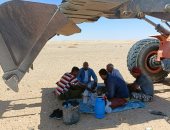 علماء مركز بحوث الصحراء يجلسون تحت "اللودر" هربا من أشعة الشمس.. صور