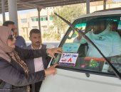 لصق استيكرات بالتعريفة الجديدة على سيارات الأجرة بحى الكوثر فى سوهاج