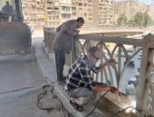 إصلاح وصيانة الأسوار الحديدية بكوبرى أرض اللواء فى الجيزة.. صور
