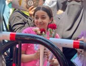 طفلة تنتظر شقيقتها بالورود أمام لجان الثانوية العامة فى الجيزة