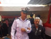 رجل شرطة يساعد مسنا للوصول إلى لجنته الانتخابية فى حدائق القبة (صورة)