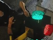 حادث غريب.. رجل يعلق برأسه داخل إشارة مرور بالصين بعد اصطدام دراجته النارية "فيديو"