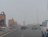 ضباب الشبورة يغطى طريق المحور وشوارع 6 أكتوبر ويبطئ حركة السيارات.. صور