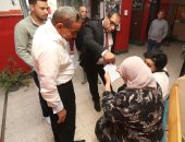 رئيس لجنة يخرج لسيدة مريضة لمساعدتها على الإدلاء بصوتها بانتخابات النواب