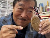 عالم أثار يابانى شهير يعرب عن سعادته لتلقيه كعكة بشكل جعران من السفارة المصرية