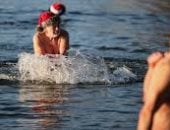 سباحو برلين بملابس سانتا كلوز يتحدون الصقيع بغطسة مجنونة فى بحيرة متجمدة