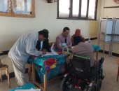 رئيس لجنة بجولة إعادة انتخابات النواب بمركز بلاط يساعد ناخب على كرسى متحرك للإدلاء بصوته