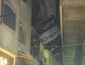 الأمن يدفع بمعدات لإنزال أتوبيس تعلق بين منزل دائرى أحمد عرابى وعقار.. صور