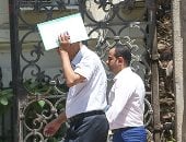 طاقية وشمسية.. المصريون يواجهون ارتفاع درجات الحرارة فى الشوارع